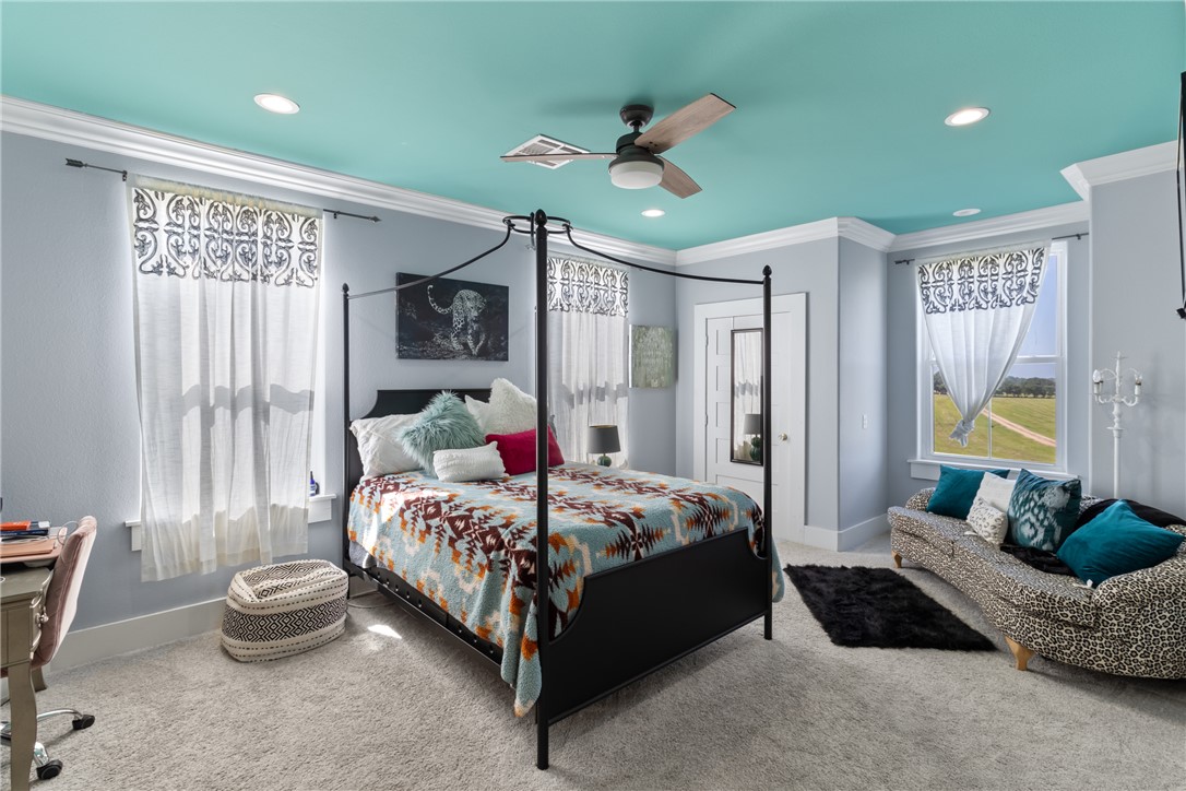 1725 Stokes Road New Ulm, TX 78950 - Photo 37 of 50 a bedroom with a bed and a chandelier