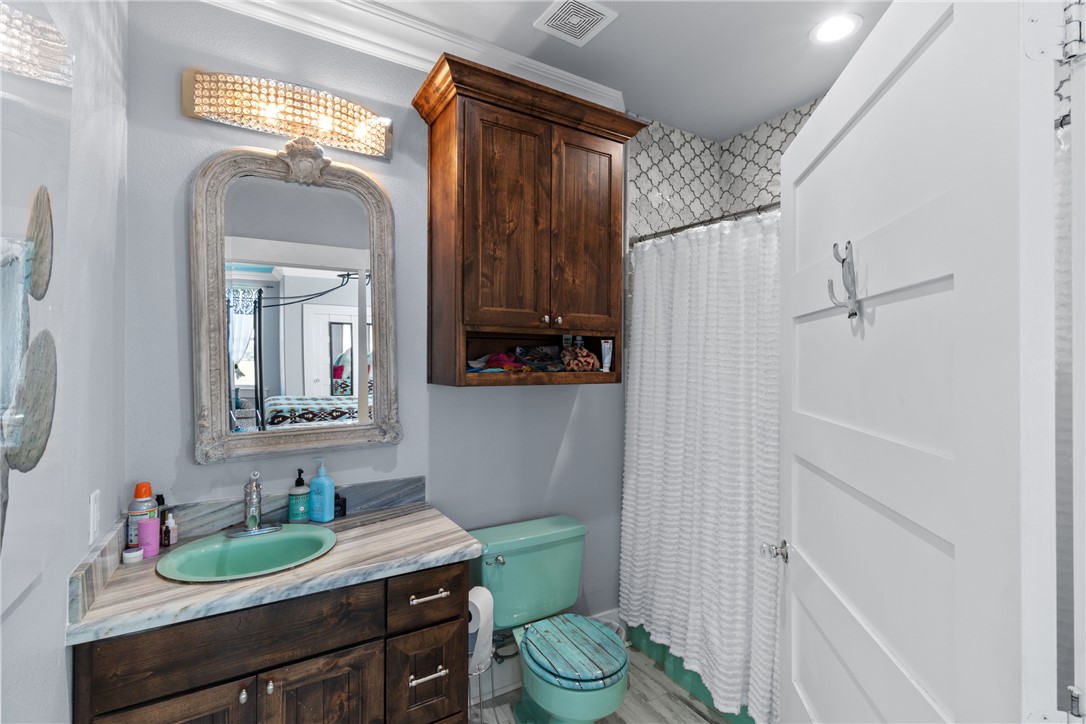 1725 Stokes Road New Ulm, TX 78950 - Photo 39 of 50 a bathroom with a granite countertop sink toilet and a mirror