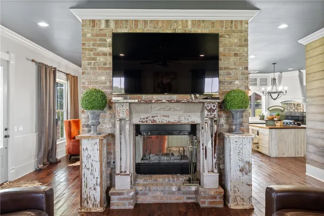 a kitchen with stainless steel appliances granite countertop a refrigerator a stove a sink and a dining table with wooden floor