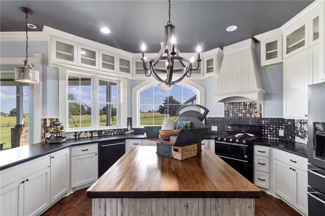 1725 Stokes Road New Ulm, TX 78950 - Photo 48 of 50 a kitchen with stainless steel appliances granite countertop a stove a sink dishwasher a dining table and chairs with wooden floor