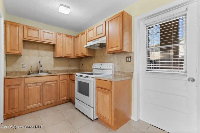 a kitchen with a refrigerator a stove top oven and cabinets