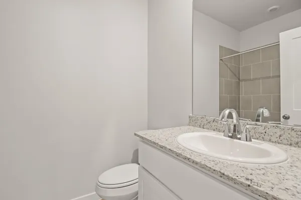 a bathroom with a granite countertop sink toilet and a mirror