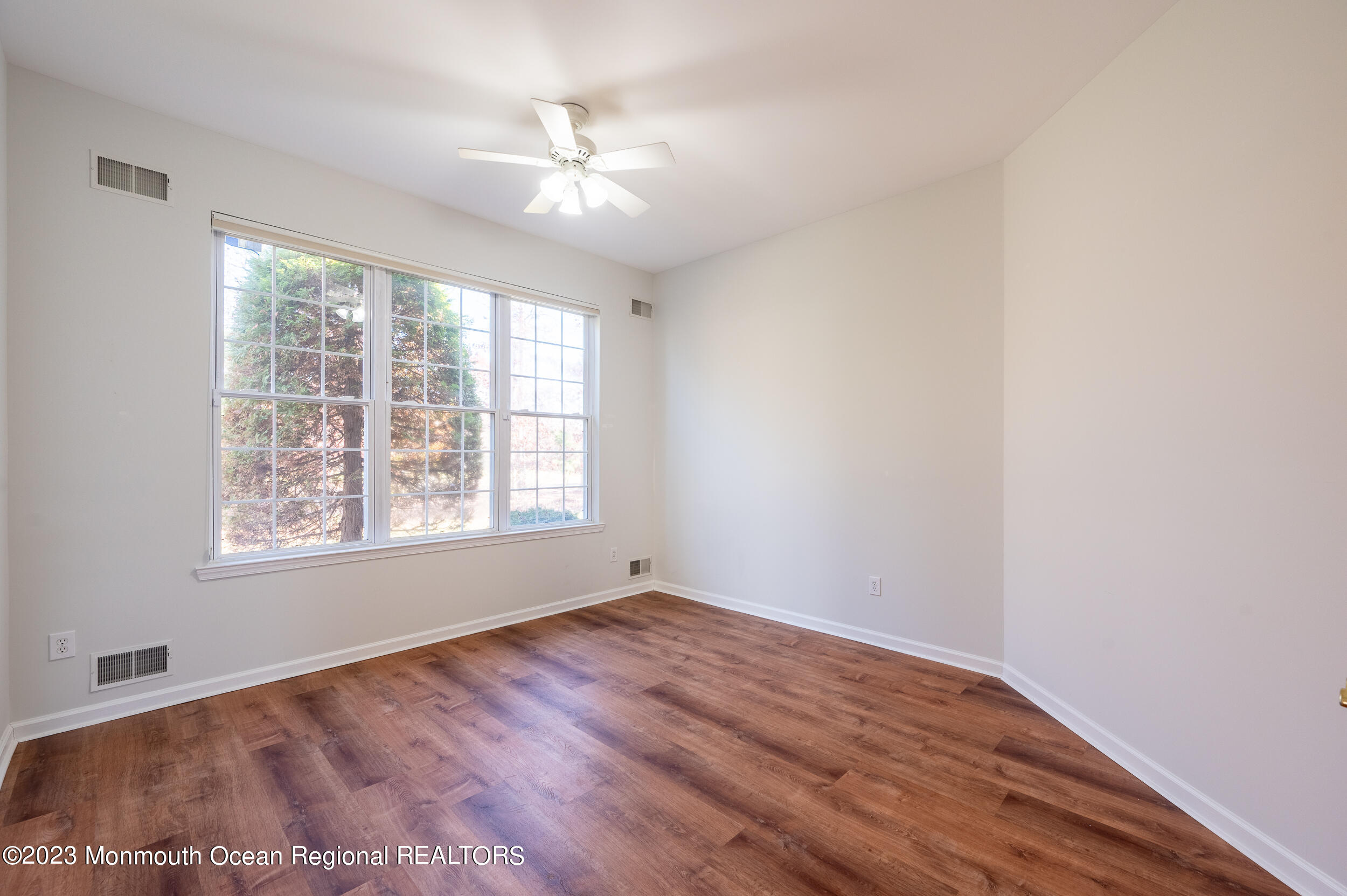 27 Shoal Road Jackson, NJ 08527 - Photo 20 of 42 a view of an empty room with wooden floor and a window