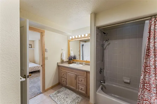 a bathroom with a granite countertop sink a toilet and shower