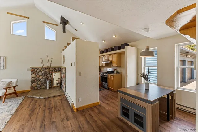 a living room with stainless steel appliances kitchen island furniture and wooden floor
