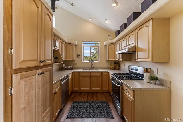 a kitchen with stainless steel appliances a sink stove and cabinets