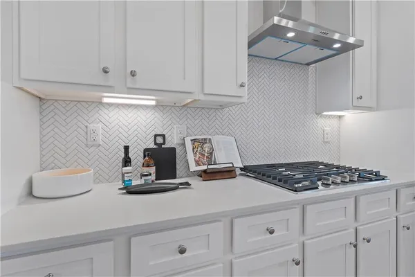 a kitchen with white cabinets and appliances