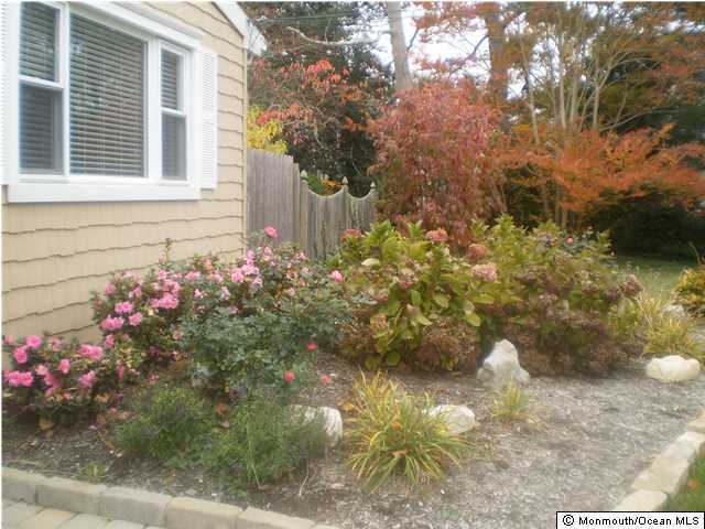 539 Woodland Avenue Brielle, NJ 08730 - Photo 19 of 20 a front view of a house with a yard and garden