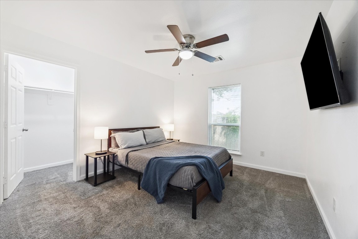 2631 Stevens Street Houston, TX 77026 - Photo 13 of 25 a bedroom with a bed a flat screen tv and a ceiling fan
