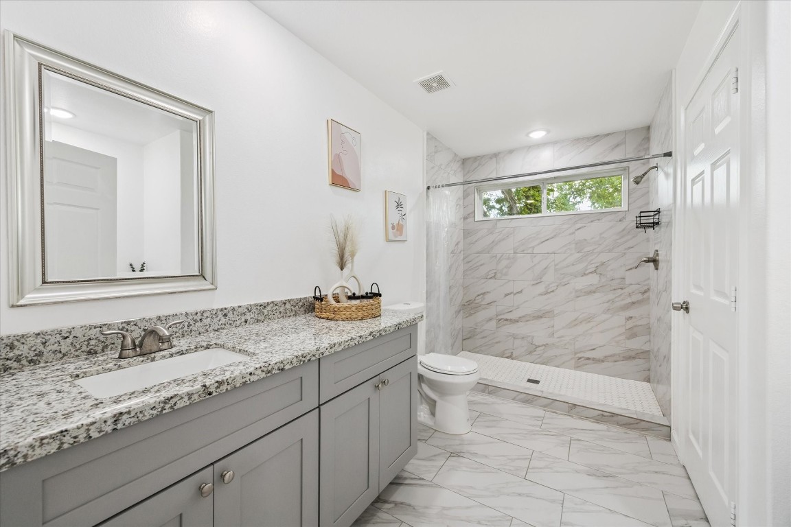 2631 Stevens Street Houston, TX 77026 - Photo 18 of 25 a bathroom with a granite countertop sink toilet and shower