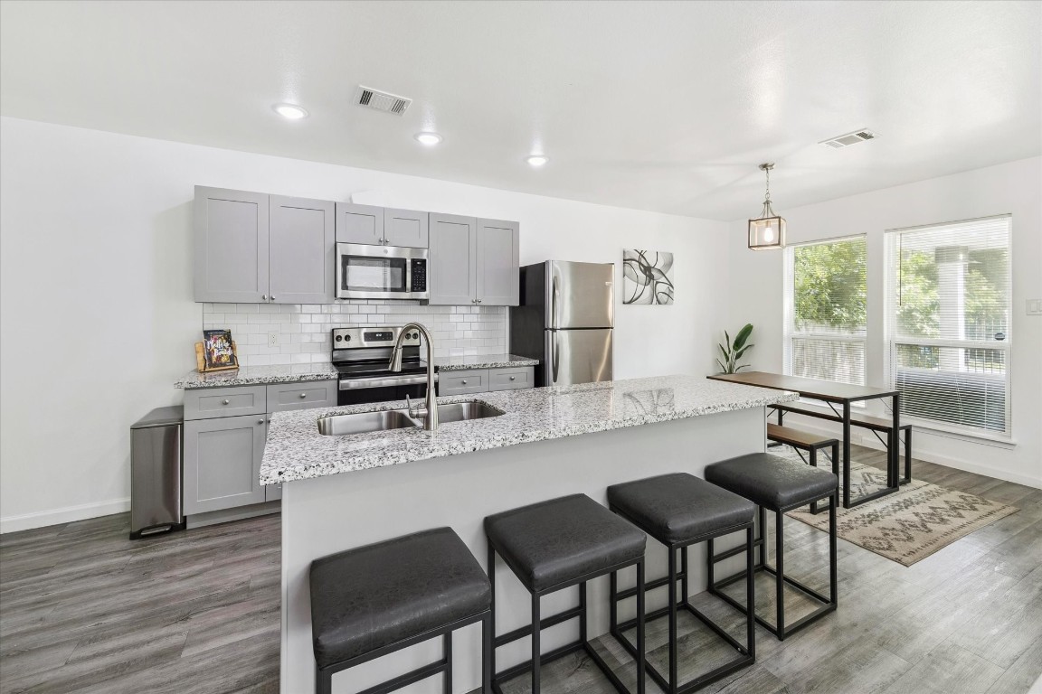 2631 Stevens Street Houston, TX 77026 - Photo 3 of 25 a kitchen with granite countertop a table chairs microwave and cabinets