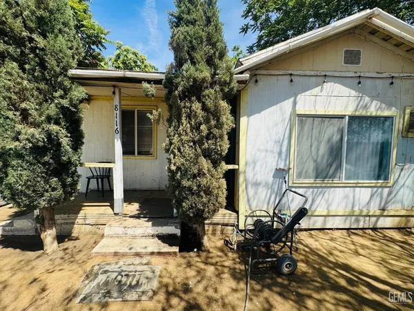a view of a house with backyard and sitting area