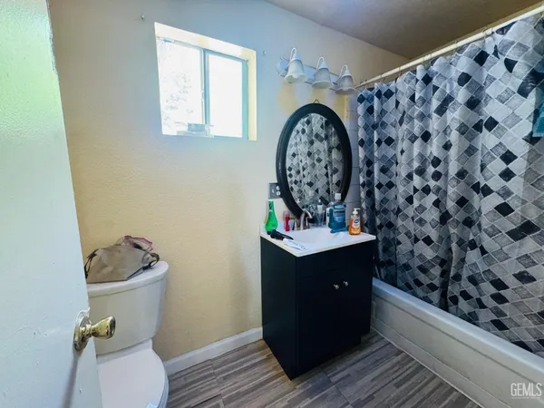 a bathroom with a granite countertop toilet and a sink