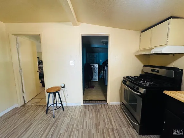 a kitchen with granite countertop a stove and a wooden floor