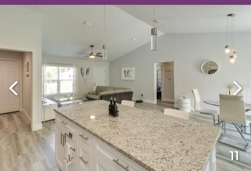 2081 Southwest 153rd Loop Ocala, FL 34473 - Photo 6 of 20 a view of a kitchen with granite countertop a sink white cabinets and chairs