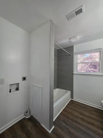 a bathroom with a bathtub and shower