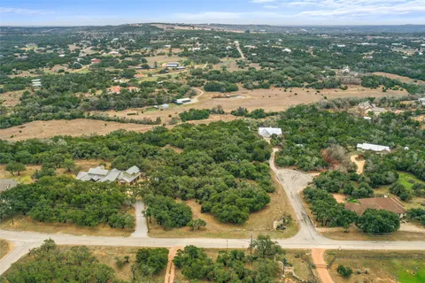 an aerial view of residential houses with outdoor space and trees