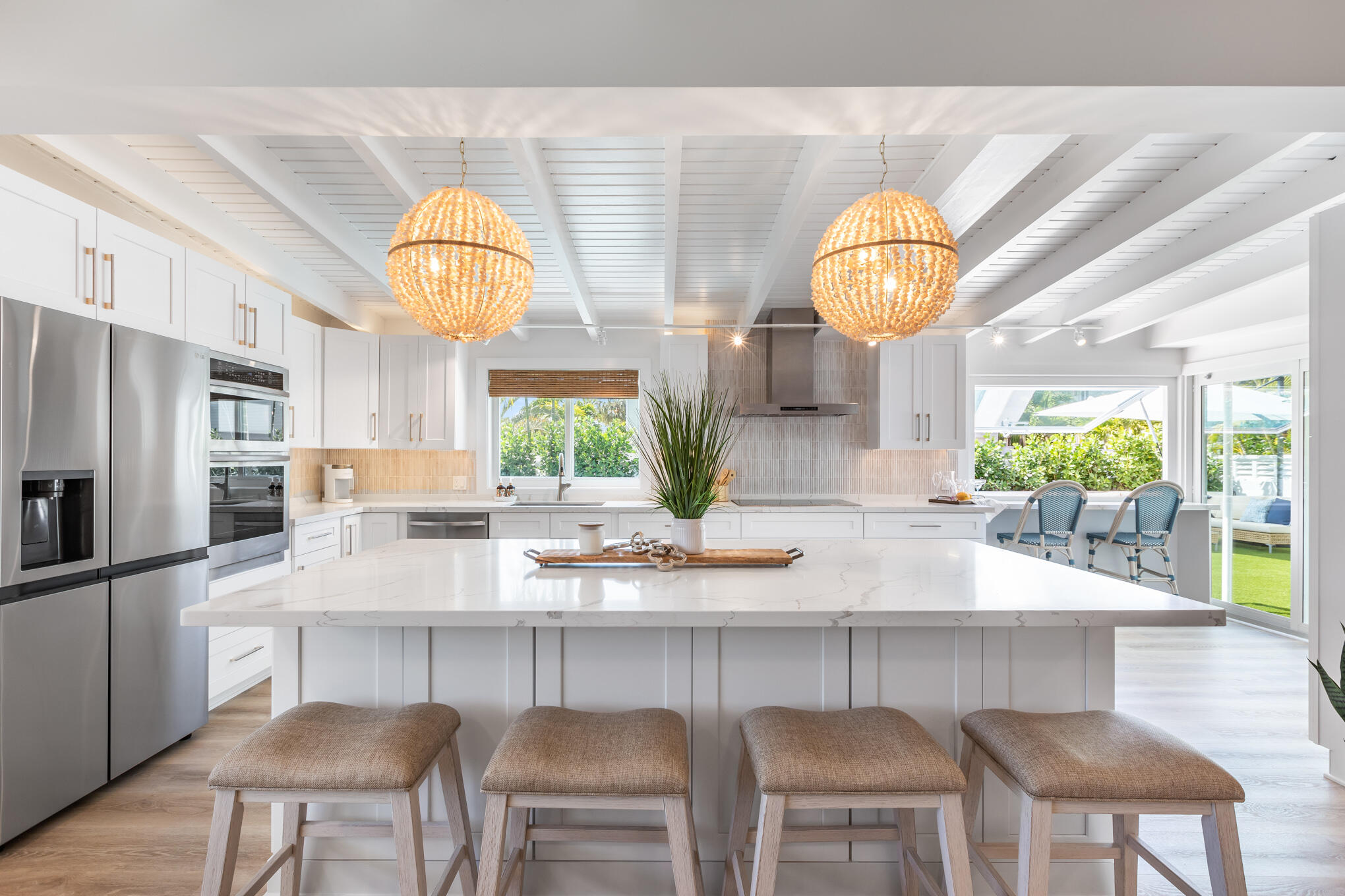 1701 Atlantic Boulevard Key West, FL 33040 - Photo 12 of 39 a kitchen with stainless steel appliances kitchen island granite countertop a table and chairs in it