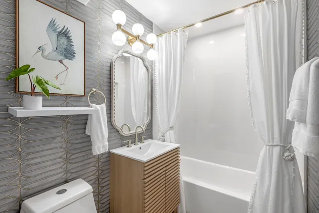 a bathroom with a granite countertop sink a toilet and shower