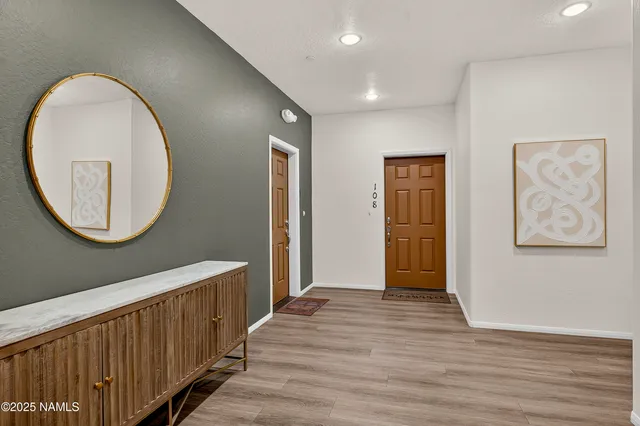 a view of a hallway with entryway wooden floor and front door