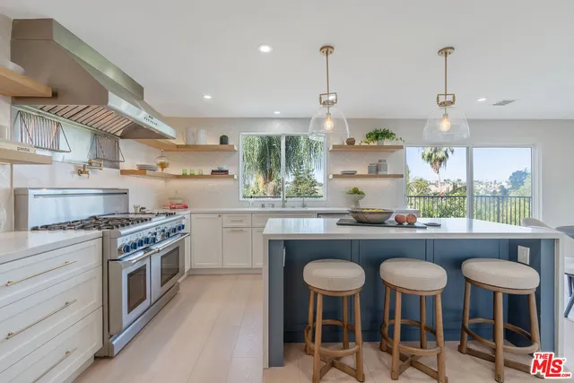 a kitchen with stainless steel appliances granite countertop table chairs sink and wooden floor