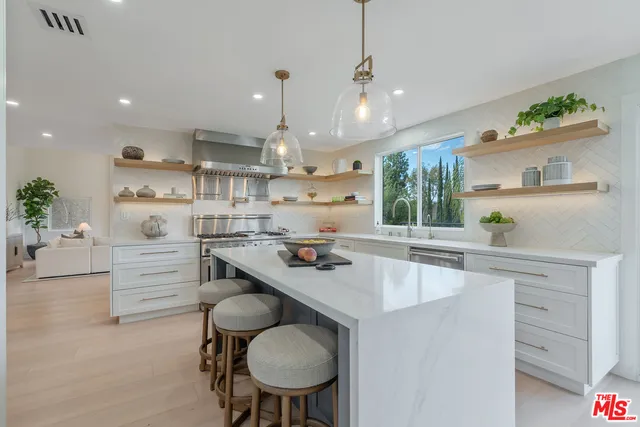 a kitchen with white cabinets and chairs
