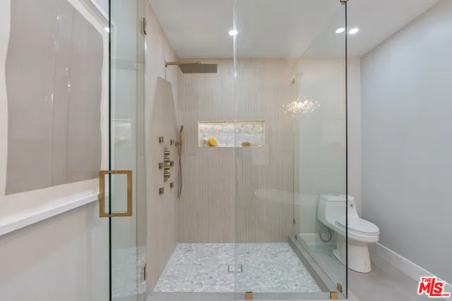 a spacious bedroom with a bed and a chandelier