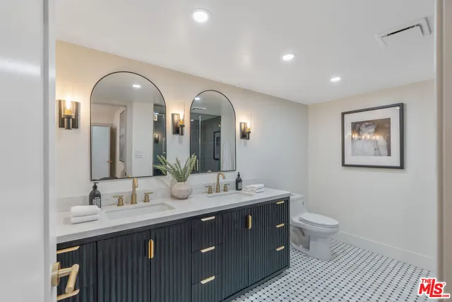 a bathroom with a granite countertop double vanity sinks and a mirror