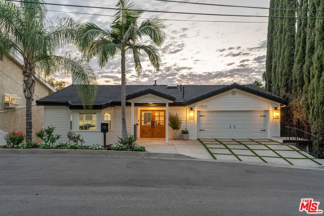 a view of a swimming pool with a patio and plants