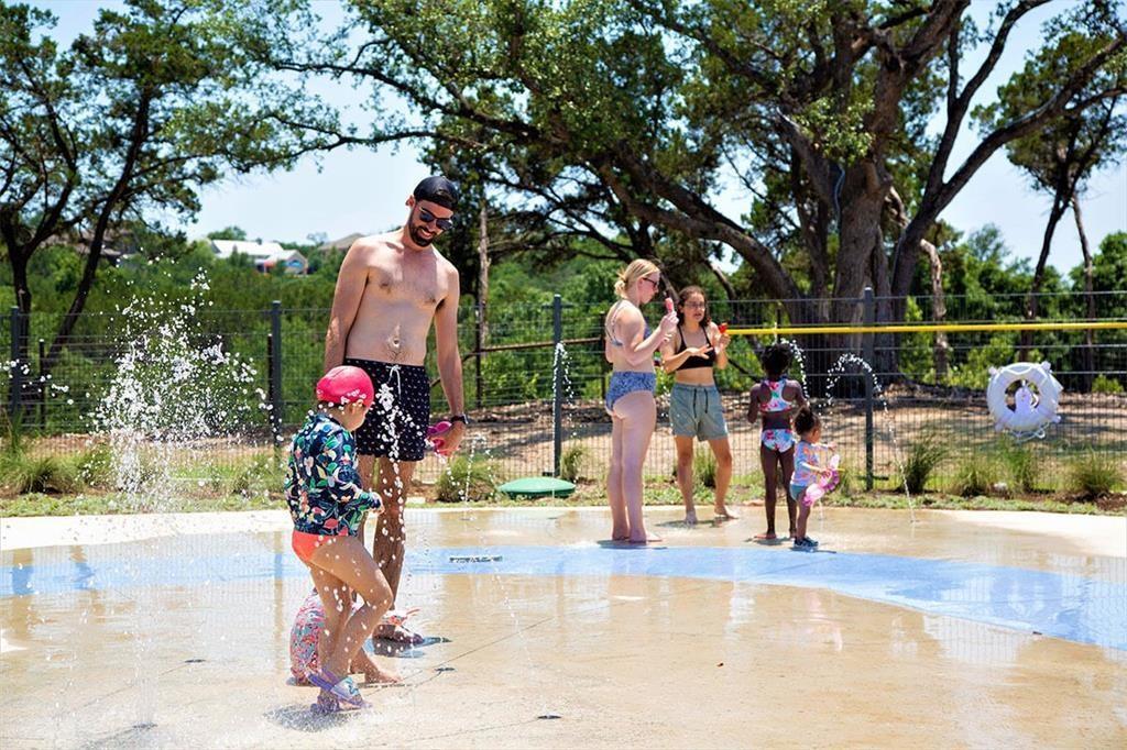 504 Sundance Ridge Georgetown, TX 78628 - Photo 31 of 34 A vibrant community splash pad offers refreshing outdoor recreation surrounded by mature trees.
