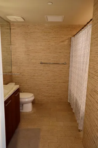 a bathroom with a toilet and a shower