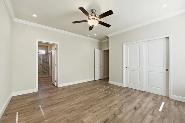 an empty room with closet and ceiling fan