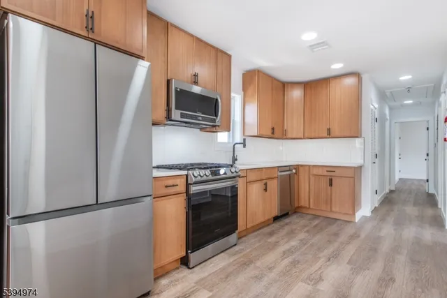 a kitchen with stainless steel appliances a refrigerator stove and microwave