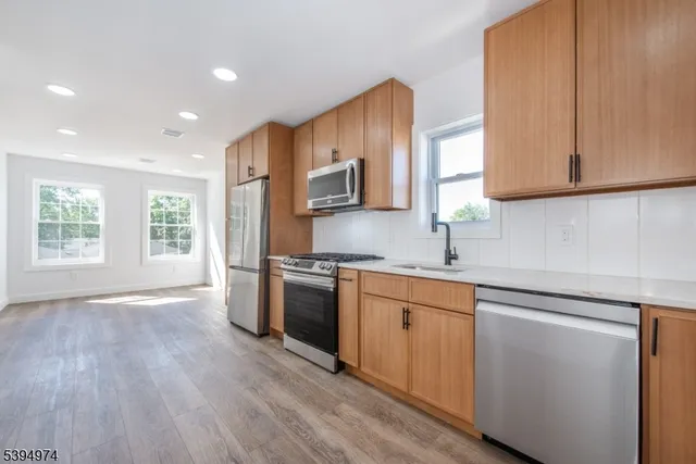 a kitchen with granite countertop wooden floors and stainless steel appliances