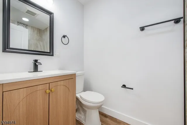 a bathroom with a toilet a sink and mirror