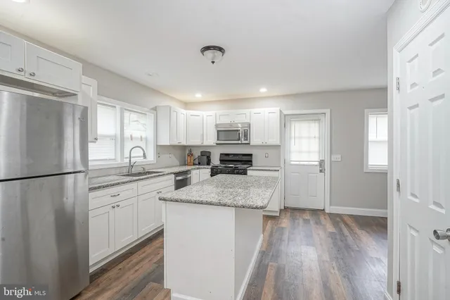 a kitchen with a refrigerator a sink and cabinets