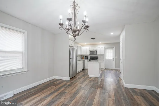 a view of a kitchen with a sink wooden floor and a window