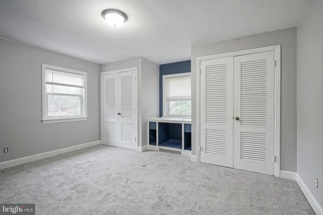 an empty room with windows and closet