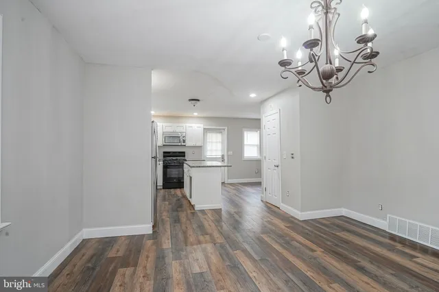 a view of a kitchen with a white cabinets and wooden floor