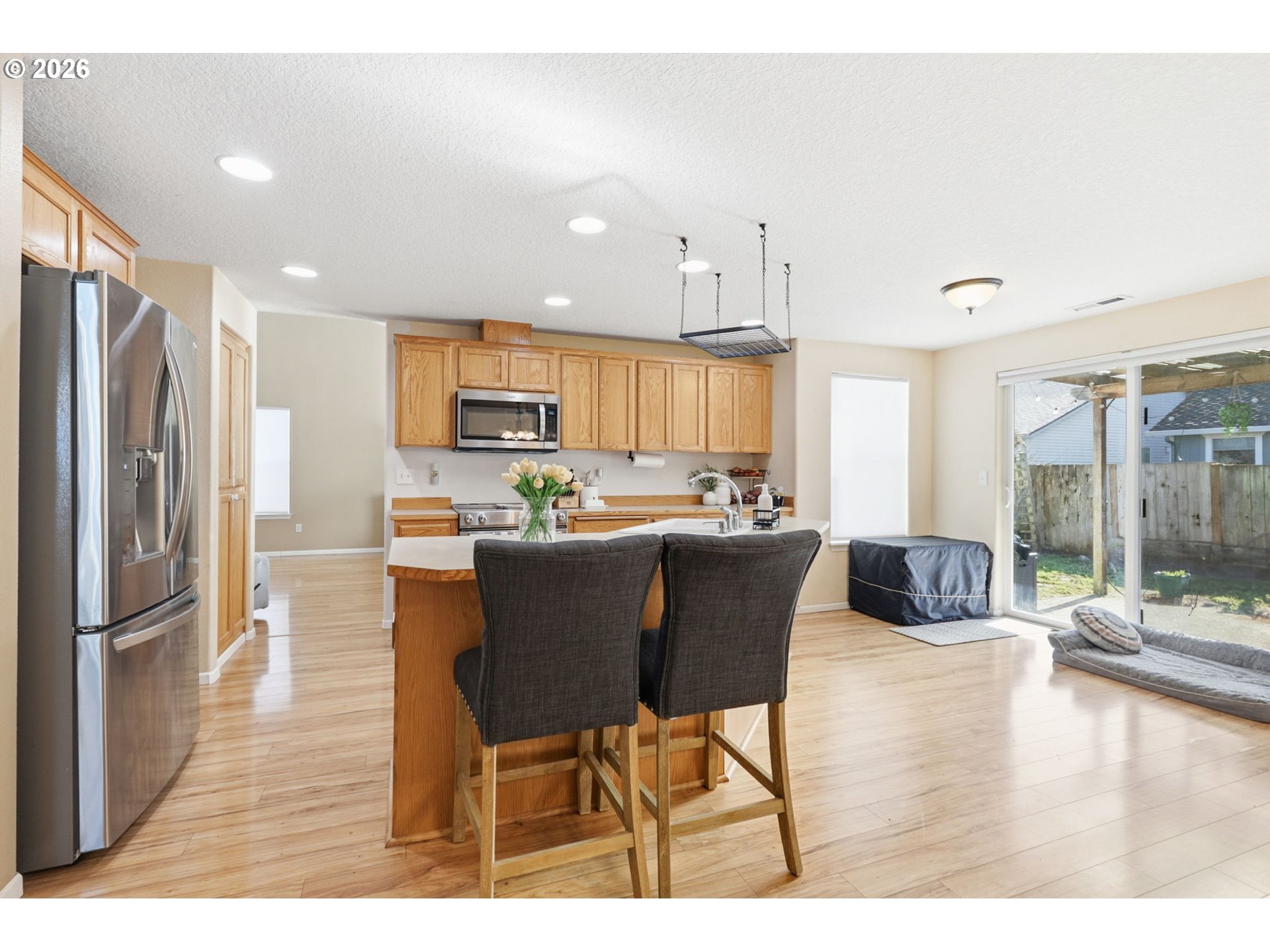 227 West 14th Street Lafayette, OR 97127 - Photo 16 of 36 a kitchen with stainless steel appliances granite countertop a refrigerator a stove a sink a dining table and chairs with wooden floor