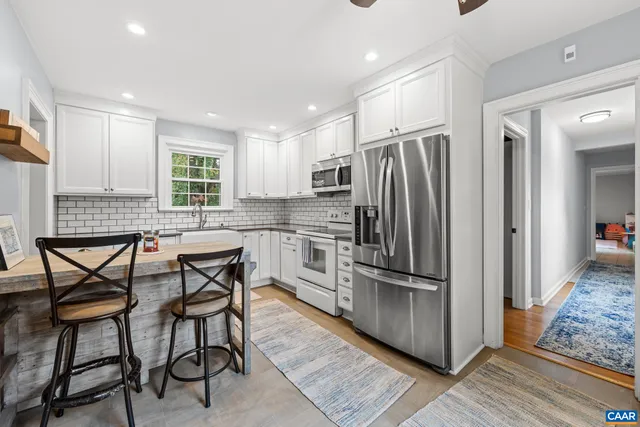 a kitchen with stainless steel appliances granite countertop a refrigerator and a stove top oven
