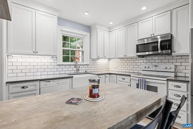 a kitchen with stainless steel appliances granite countertop a sink stove and microwave
