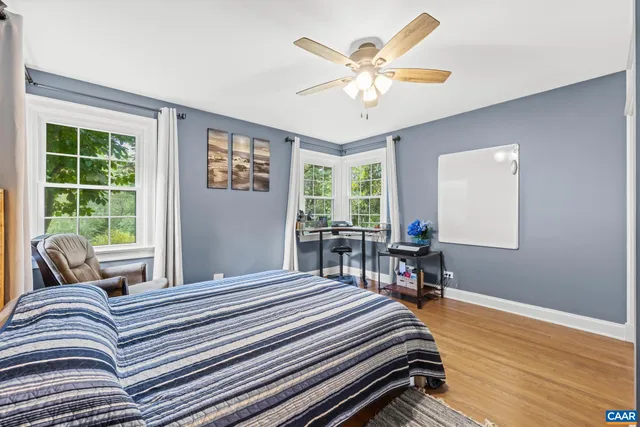 a bedroom with a bed and a large window with chair