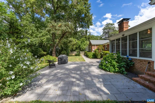a view of a chair and table in the back yard of the house