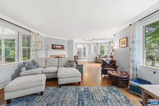 a living room with furniture wooden floor and a large window