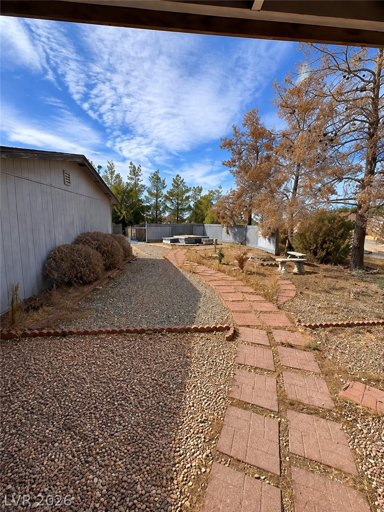 5561 Doubletree Road Pahrump, NV 89061 - Photo 16 of 19 A structured brick pathway winds through the gravel-landscaped yard under wide open skies.