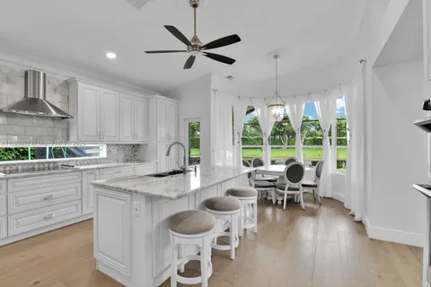 a open kitchen with a table chairs and white cabinets