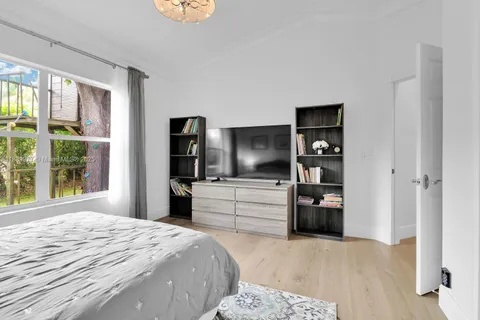 a bedroom with a bed and a large window