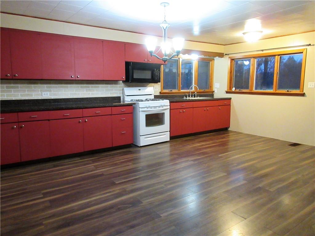 993 Bartley Road Parker, PA 16049 - Photo 4 of 25 a large kitchen with stainless steel appliances granite countertop a stove a sink and a wooden floors