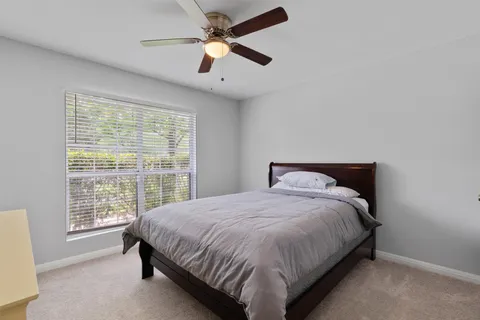 a large bed sitting in a bedroom next to a window